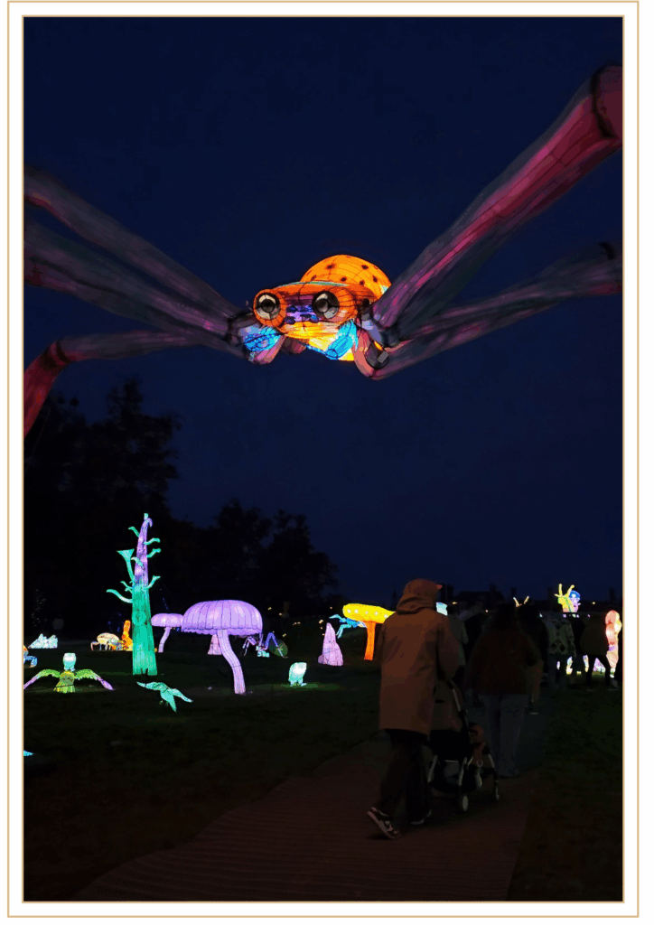 araignee lumineuse geante dans un parcours nocturne avec decorations colorees